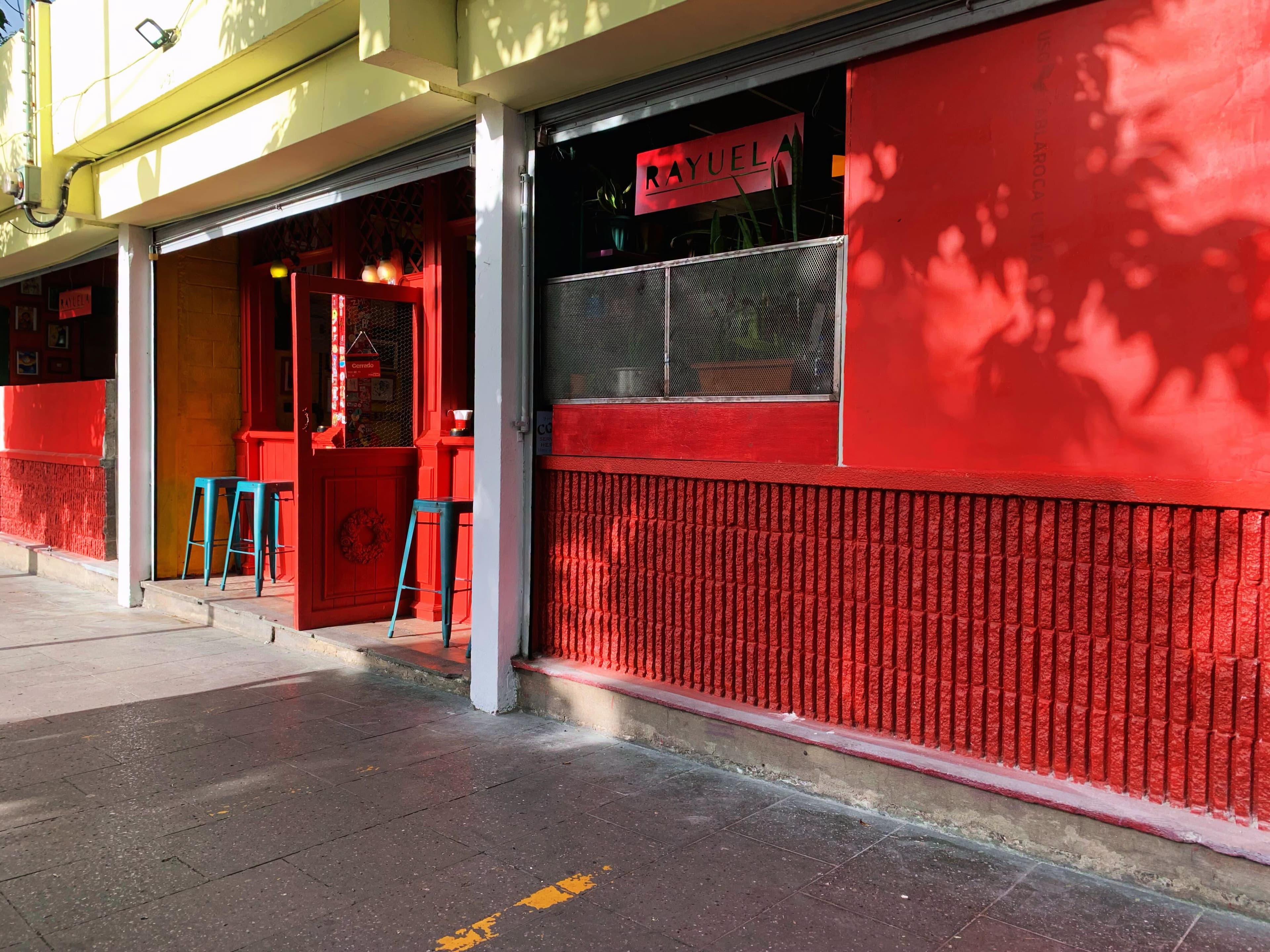 Fachada de Rayuela al anochecer, letrero encendido